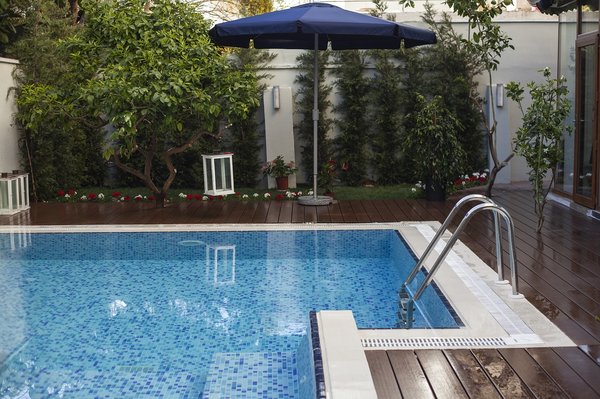 How can you minimize the visual impact of pool safety fences in UK gardens?